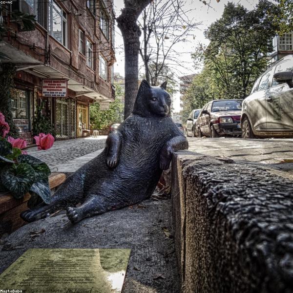 Ritratto in bianco e nero di Maestro Paolo Conti, naso profumiere milanese tra i suoi flaconi