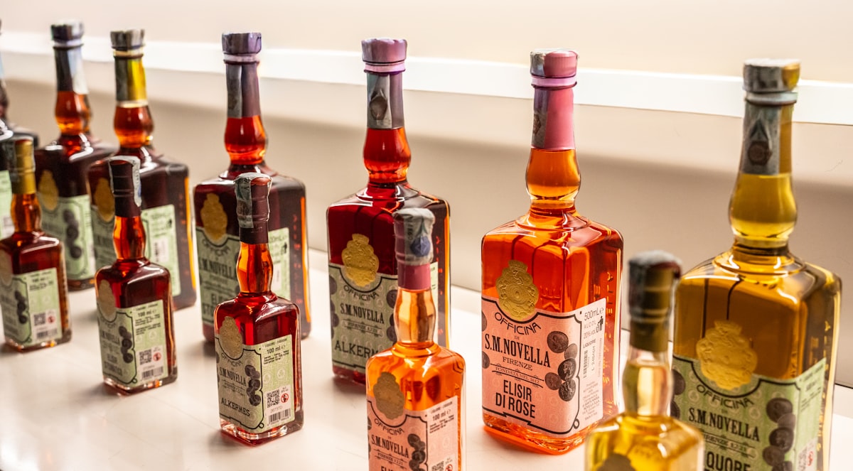 Flaconi in vetro ambrato, spazzola a setole naturali e sacchetto di lino su superficie in pietra, luce dorata